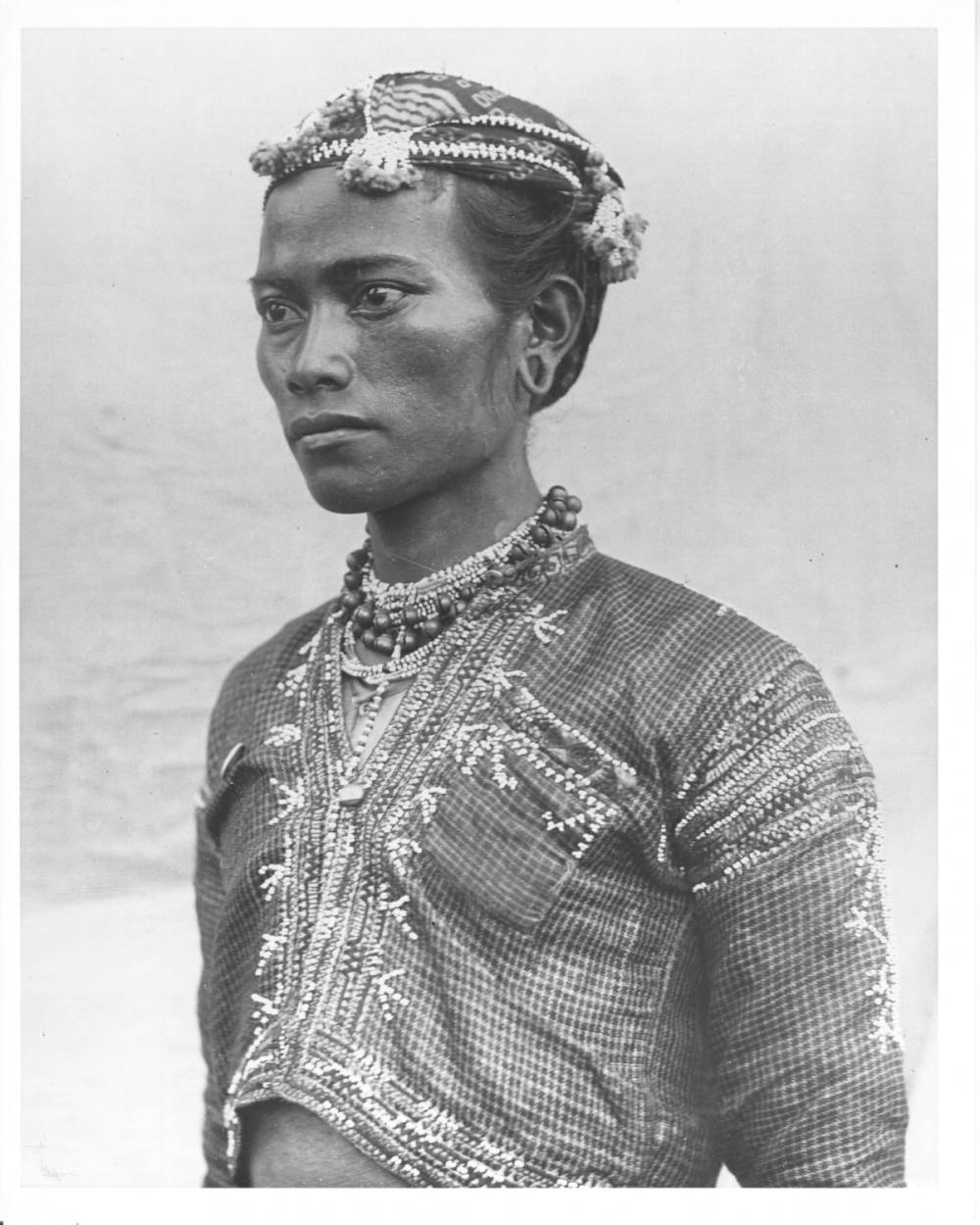 <p>Portrait photograph of Bagobo man in traditional dress. Headhunter: Head hunting is the Bagabos highest pursuit. The tribe rates men by the number of heads they get. Their knives are 20 inches long. Number 940: The number ‘940’ is written at the lower left-hand corner of the photograph.</p>
