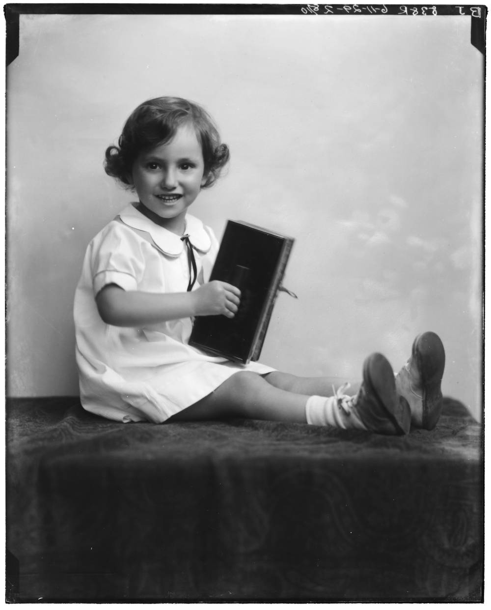 <p>Carolyn Strauss seated with book</p>
