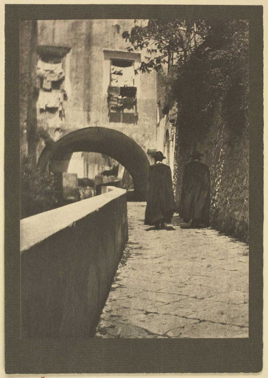 <p>Photograph of two priests walking down a lane in Amalfi, Italy. Their backs are to the camera. Signed: Grace Parrish, 1913.</p>
